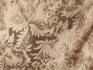 Vista macro detallada de la textura de la tela floral marrón y beige en el vestido ajustado