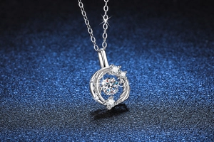 Macro shot of silver dancing moissanite pendant with a round hollow frame and small diamonds