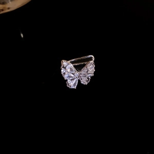 Close-up of a silver butterfly ear cuff with sparkling zircon stones on black background