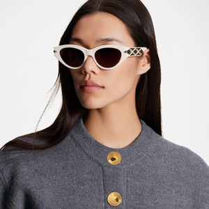 Detailed view of white cat-eye sunglasses with golden malletage pattern on temple