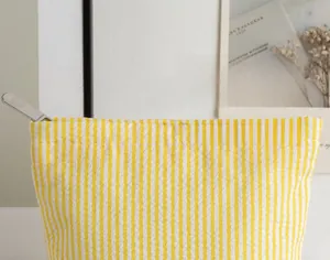 Macro detail of yellow and white striped seersucker underwear bag with zipper texture