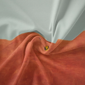 Macro shot of bicolored lightweight silk scarf in light blue and rust orange hues