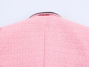 Nahaufnahme der rosa Tweed-Stoffstruktur und Nackennaht an einem britischen Blazer