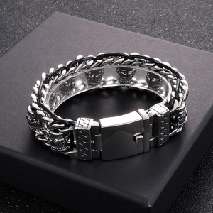 Detail of silver stainless steel skull bracelet with punk style dragon bone chain link