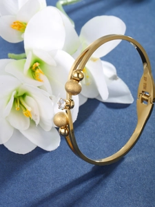 Detailed view of gold stainless steel bracelet with frosted beads and zirconia stone