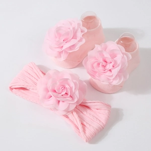 Détails d'un ensemble chaussettes et bandeau rose pour bébé avec fleurs en tissu