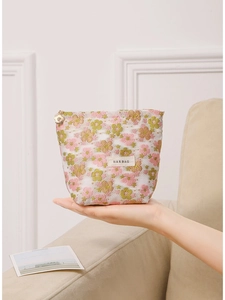 Floral embroidered mesh makeup bag with a gold star zipper for travel storage