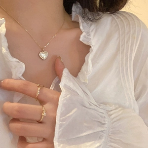 Elegant gold heart pendant necklace and rings set featuring a cat-eye stone inlay