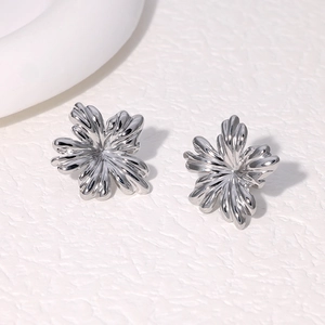 Detailed view of silver flower stud earrings with sleek petals and metallic finish