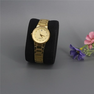 Macro view of gold quartz watch with crystal indices on a black velvet cushion