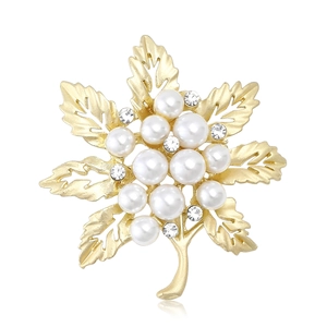 Elegant golden leaf brooch with white pearls and rhinestones on a white background