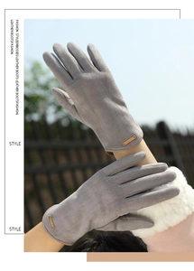 Detailed view of women's grey suede gloves with gold metal plate and plush faux fur cuffs