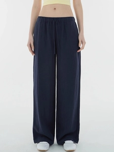 Detail of deep blue wide-leg pants featuring elastic drawstring waist and linen texture