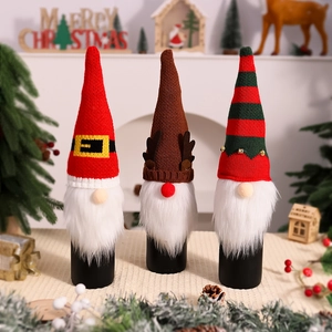 Three Christmas knitted wine bottle covers featuring Santa, reindeer and forest elf designs