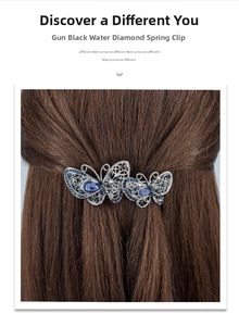 Détail de la pince à cheveux papillon noir fusil avec strass bleus sur cheveux