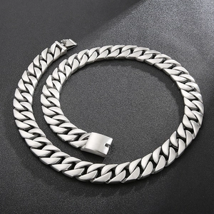Close-up of a silver stainless steel Cuban link chain for men on a textured black surface