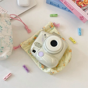 Quilted floral drawstring pouch storing Fujifilm Instax camera for stylish protection