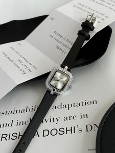 Détail macro du boîtier carré serti de diamants avec chiffres romains et bracelet cuir