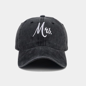 Detailed close-up of white Mrs. cursive embroidery on a washed dark gray baseball cap