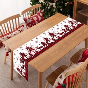 Christmas table runner with red and black plaid border, reindeer and snowflakes on wood table