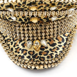 Close-up of leopard print military hat with golden studs and sparkling rhinestones