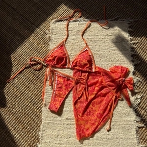 Vue à plat d'un bikini trois pièces à imprimé floral avec bordure festonnée blanche