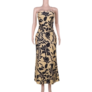 Detail view of yellow backless maxi dress with bold black floral print on a mannequin