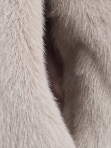 Macro shot of soft faux fur fabric showing light grey long pile texture on a jacket