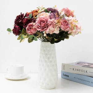 Pink artificial hibiscus roses and hydrangeas in a white textured ceramic vase decor