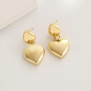 Detailed close-up of polished 24K gold-plated heart-shaped drop earrings for women