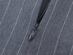 Détail de la fermeture éclair invisible sur le tissu gris à rayures et texture du short