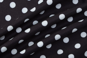 Makro-Detail der Stoffstruktur mit klassischem schwarz-weißem Polka-Dot-Muster auf dem Tuch