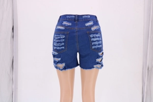 Detail of high waist distressed denim shorts featuring back pockets and ripped hollow cutouts