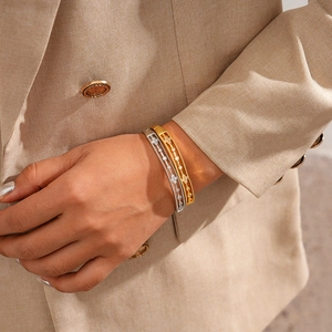 Close-up of 18k gold and silver plated openwork bangles with zircon flower inlay
