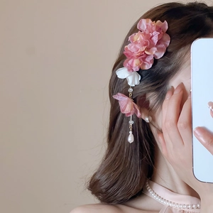 Détail d'une pince à cheveux fleur en soie avec pampilles métalliques et perles gouttes