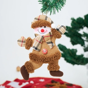 Detailed plush snowman ornament with red checkered hat hanging on a green Christmas tree