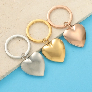 Three polished heart-shaped locket keychains in silver, gold, and rose gold stainless steel