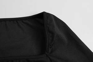 Close-up of square neckline tailoring and premium double-needle stitching on black dress