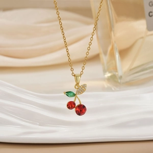 Detailed shot of red cherry pendant with sparkling white zircons on a gold chain