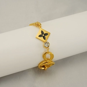Luxurious gold titanium steel bracelet featuring black four-petal flower and diamond accent