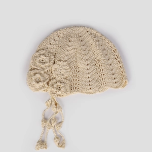 Close-up of handmade crochet beret with floral decorations and fringe tassels