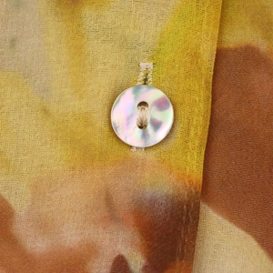 Détail macro du tissu à imprimé fleuri avec bouton nacré sur une blouse décontractée
