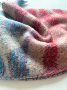 Gros plan du tissu doux imitation cachemire montrant le motif à carreaux rose et bleu