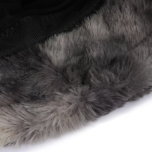 Détail de la fourrure synthétique grise et du tissu noir sur un chapeau d'hiver