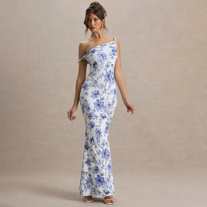 Detail view of the elegant blue floral pattern on a slim-fit one-shoulder white maxi dress