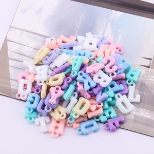 Macro view of macaron acrylic English letter beads with top loops for DIY jewelry making
