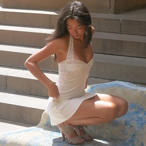 Dettaglio del patchwork in pizzo bianco e spalline all'americana su tubino corto
