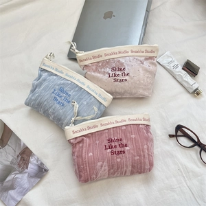 Primo piano di tre pochette in velluto blu rosa e beige con ricamo Shine Like the Stars