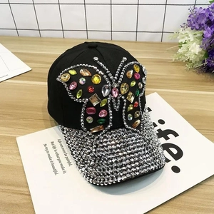 Detail of butterfly rhinestone patterns and sparkling brim on black denim baseball cap
