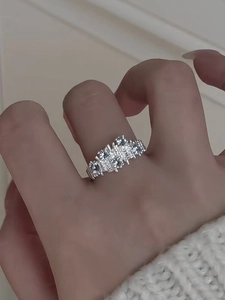 Close-up of irregular textured silver ring featuring five sparkling zircon stones on finger